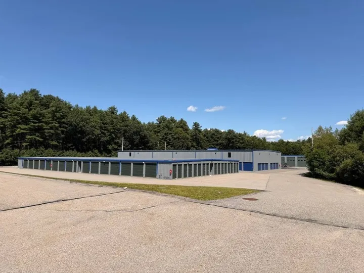 Exterior view of Storage Star Self-Storage in Coventry on 1185 Tiogue Ave with several long drive-up storage buildings under a blue sky