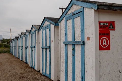 Gabled storage units with white walls and blue trim alongside a red "Building A" sign