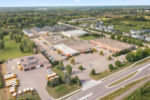 Aerial view of a commercial storage facility complex featuring orange trim, flat roofs, and parking lots