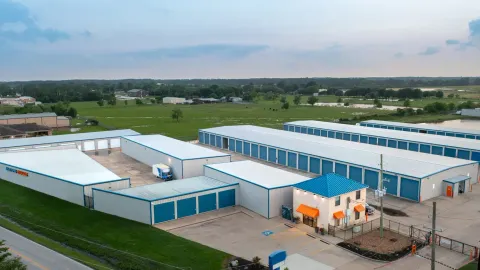 Aerial view of a self-storage facility with several long buildings and a small rental office