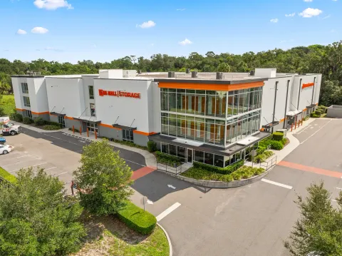 Multi-story self-storage building featuring glass windows, orange accents, and U-Haul Storage signage on a white exterior