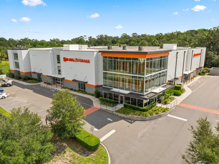 Multi-story self-storage building featuring glass windows, orange accents, and U-Haul Storage signage on a white exterior