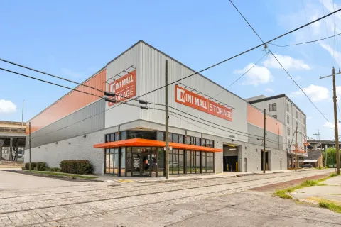 Exterior view of Mini Mall Storage building with glass entrance and drive-in loading bay next to tracks