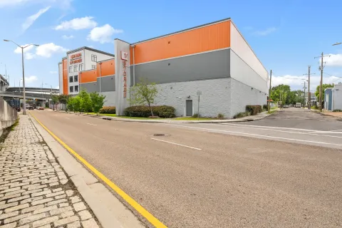 Exterior of Mini Mall Storage building with orange and gray siding located on a paved street corner