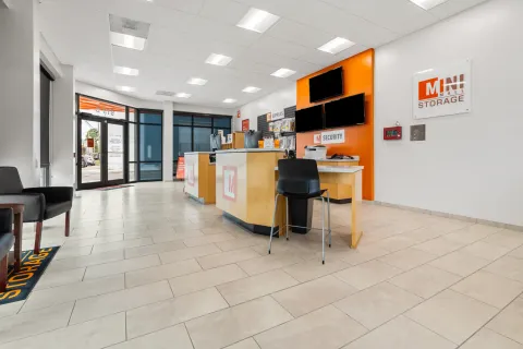 A bright rental office for Mini Mall Storage featuring customer service counters, retail supplies, and monitors