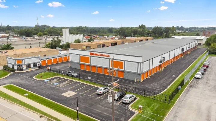 Aerial view of a U-Mall Storage facility with orange roll-up doors and a fenced parking lot
