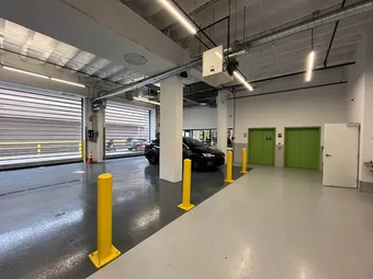 Indoor drive-up loading bay area with green elevator doors and car.