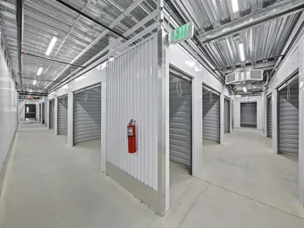 Indoor hallway with many storage units and an exit sign.
