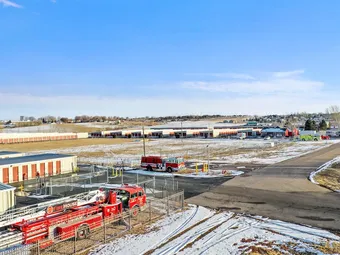 Wide view of the storage facility with buildings, roads, and parked fire truck.