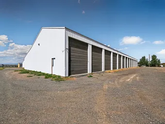 Exterior of a self storage building with dark grey unit doors.