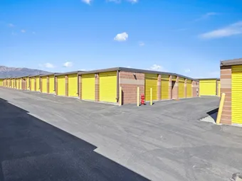 Outdoor drive-up storage units with yellow doors.