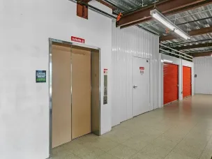 A hallway with elevator access and climate-controlled storage units in Rockledge, FL