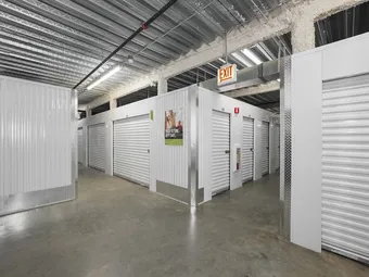 Indoor storage hallway with white roll-up unit doors.