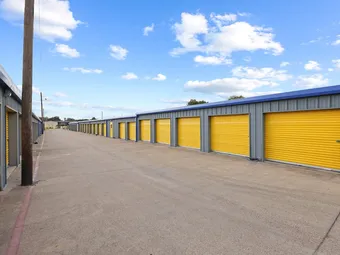 Outdoor drive-up storage units with yellow doors.