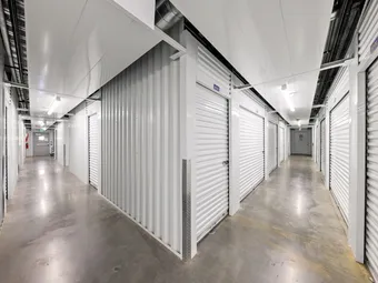 Indoor climate-controlled storage hallway with white unit doors.