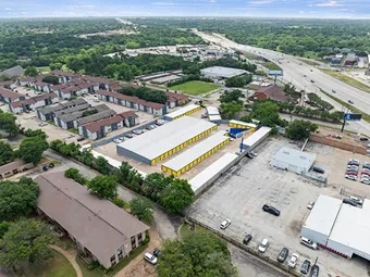 Aerial view of storage facility and surrounding area including a highway.