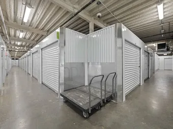 Indoor hallway with rows of storage units and a moving cart