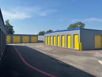 Rows of yellow drive-up storage unit doors.