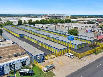 Aerial view of self-storage facility with yellow unit doors and a pole sign.