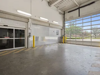Indoor loading bay with a large garage door looking outside