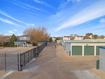 View of the office building, security gate, and drive-up storage units.