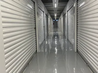Clean, well-lit interior storage unit hallway.