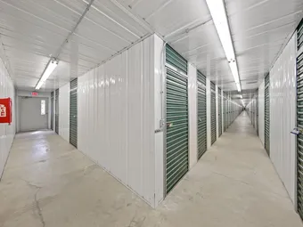 Interior hallway of storage facility with green unit doors