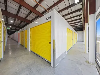 Indoor hallway of climate-controlled storage units with yellow doors.