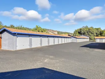 Row of drive-up storage units with sky blue doors and grey exteriors