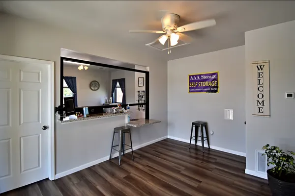 A rental office interior with wood floors, stools, a service counter, and AAA Storage signage