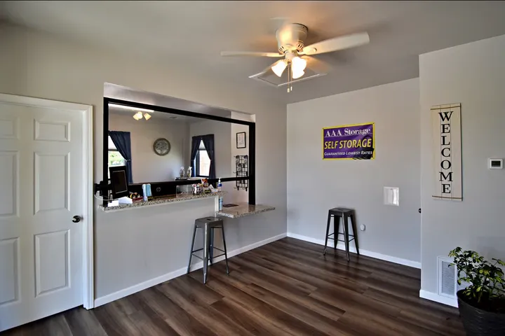 A rental office interior with wood floors, stools, a service counter, and AAA Storage signage