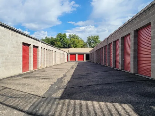 Outdoor drive-up storage units with red roll-up doors