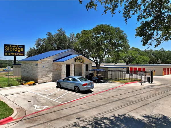 Exterior of AAA Storage office building with blue roof and silver car parked in front