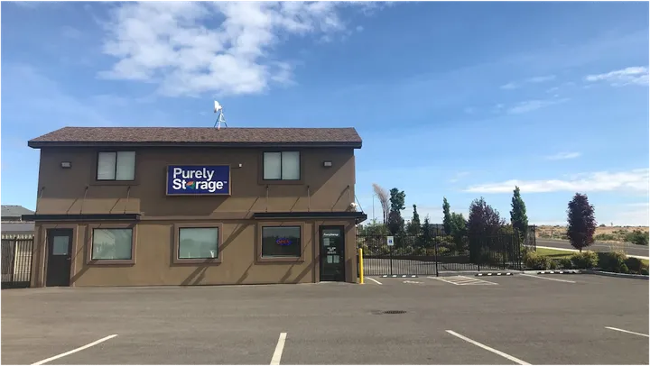 Exterior view of a Purely Storage office building with a paved parking lot and gated entrance