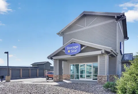 Office at Storage Star Self-Storage in Park City, UT, featuring gray siding, a sidewalk leading to a paved parking lot, and drive-up storage units