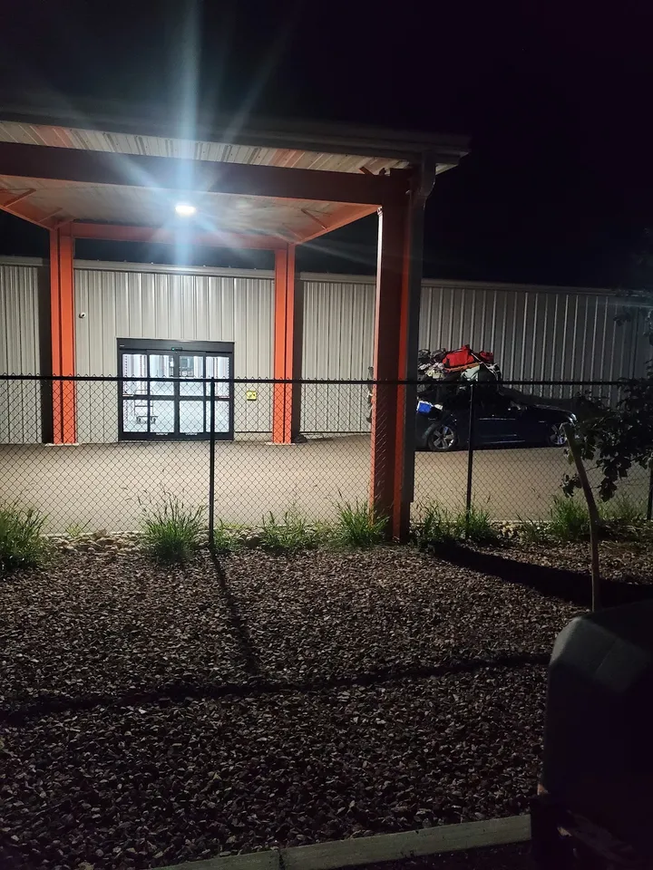 Night shot of covered loading area with a car and luggage.