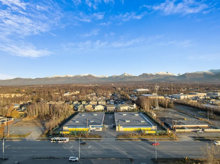 Wide aerial shot of storage facility with surrounding landscape and mountains.