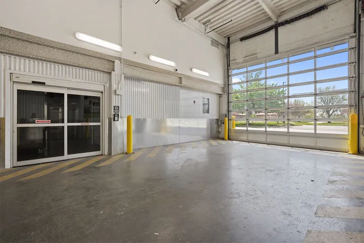 Indoor loading bay with a large garage door looking outside