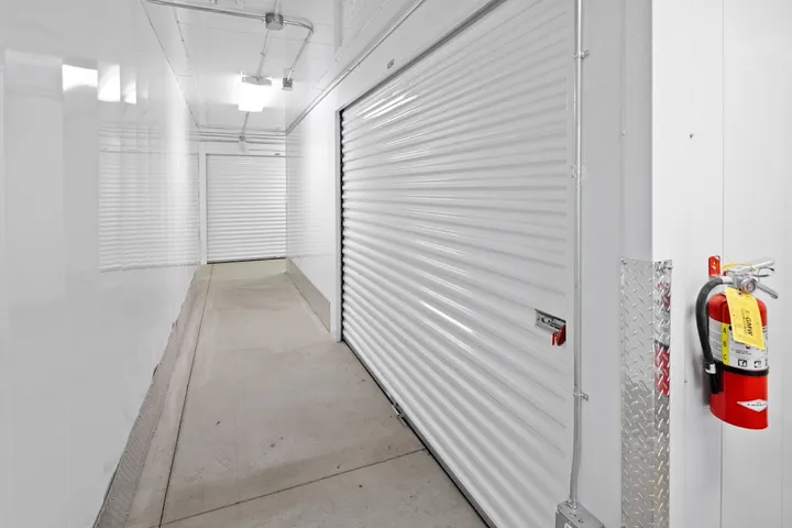 Interior hallway with white storage unit doors and fire extinguisher.