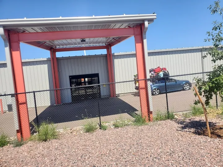 Covered loading area with a car loaded with items.