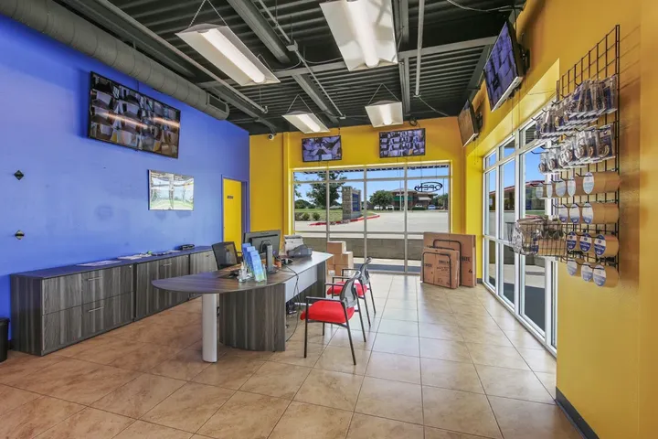 Customer service office with monitors and packing supplies display.