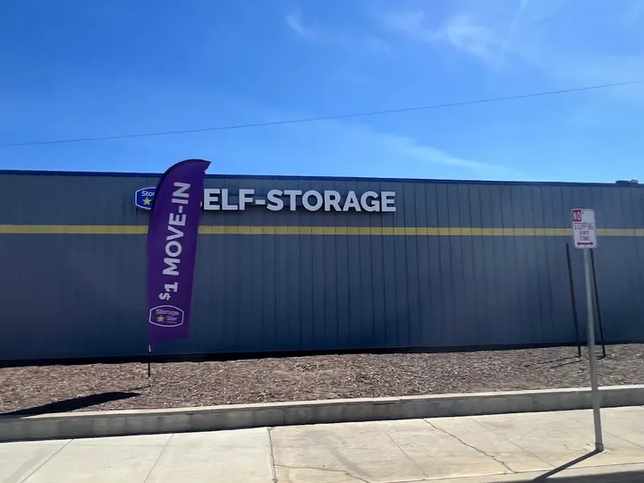 Exterior of self-storage building with large signage and a flag.