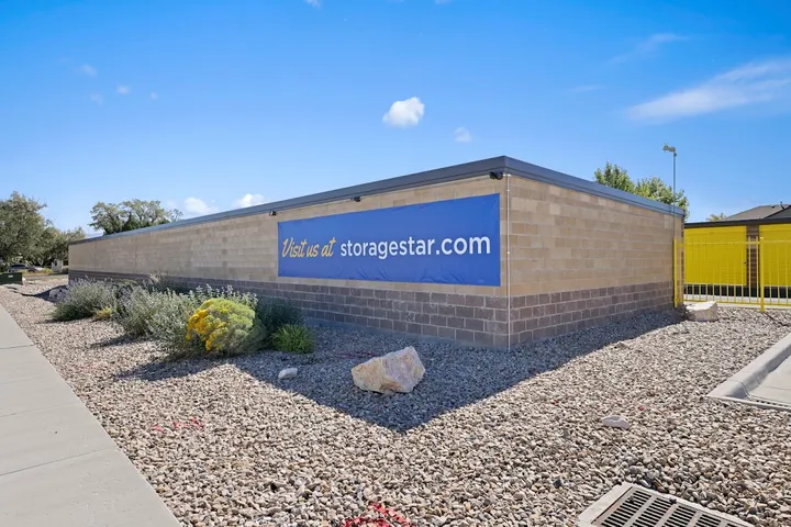 Blue banner sign on exterior wall reading "Visit us at storagestar.com".