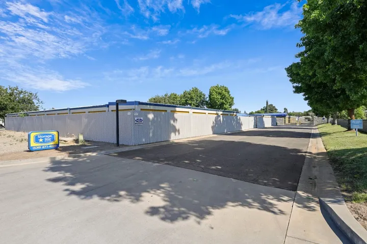 Paved drive aisle with storage units in an outdoor facility.