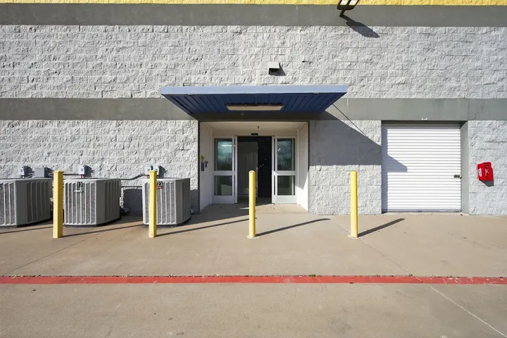Ground-level exterior view of building entrance and unit door.
