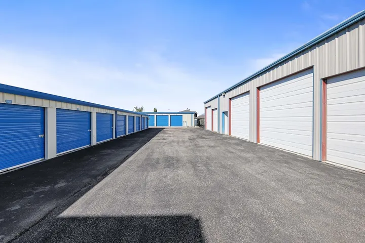 Outdoor drive-up storage units with blue doors.