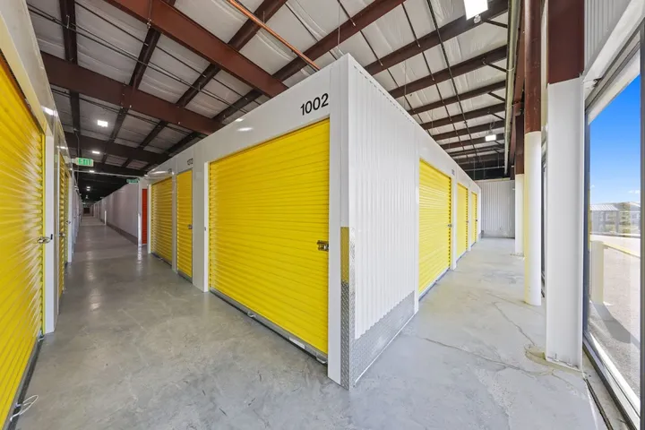 Indoor hallway of climate-controlled storage units with yellow doors.