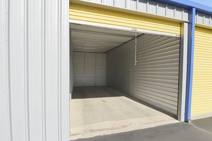 Open yellow roll-up door showing the clean interior of a storage unit.