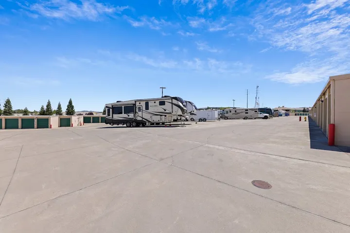 Wide view of outdoor RV parking lot with many vehicles.
