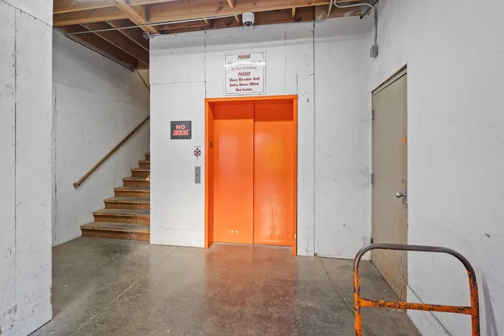 Orange elevator doors and a staircase inside the building.